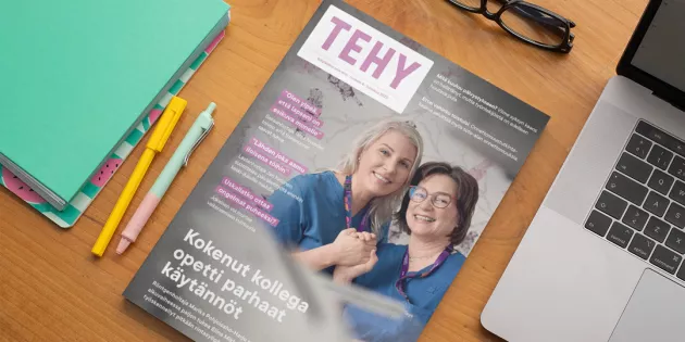 pöydällä tehy-lehti ja vieressä muistioita, kyniä ja läppäri.