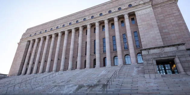 Eduskuntatalon rappuset kuvattuna talvella. Portailla hienoisesti lunta.