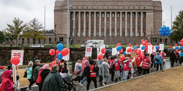 Tehyläisiä mielenosoittajia marssimassa kyltteineen kohti eduskuntataloa.