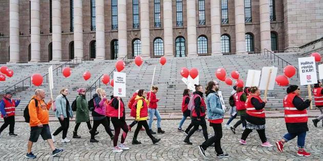 Tehyläiset marssivat eduskuntatalon ohi.