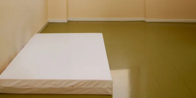 Sairaalan suljetun osaston huone, jossa lattialla pelkkä patja.