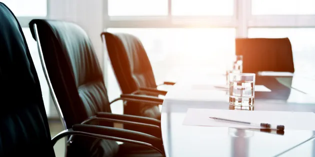 Neuvottelupöydän ääressä mustia nahkatuoleja.