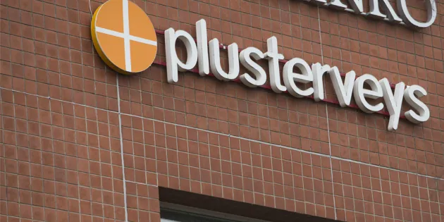 Plusterveyden logo rakennuksen tiiliseinällä.