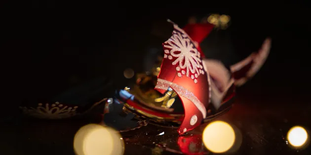 Rikkinäinen joulupallo lattialla.