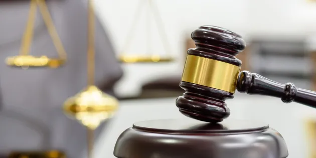 SASK valittaa rahoitusleikkauksesta hallinto-oikeuteen. Tuomarin nuija pöydällä.