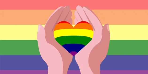 Alt-teksti: Kuvituskuva, jossa kaksi kättä pitelee sydämen muotoista esinettä sateenkaarilippua vasten. Sydän ja tausta ovat sateenkaaren väreissä, symboloiden LGBTQ+ -yhteisön tukemista ja yhdenvertaisuutta.