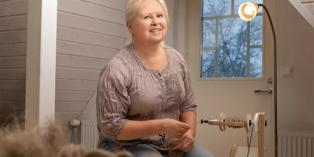 Tiina Sosoi kehrää lankaa modernilla rukilla.