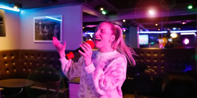 Emmi Bogdanoff laulaa karaokebaarissa.