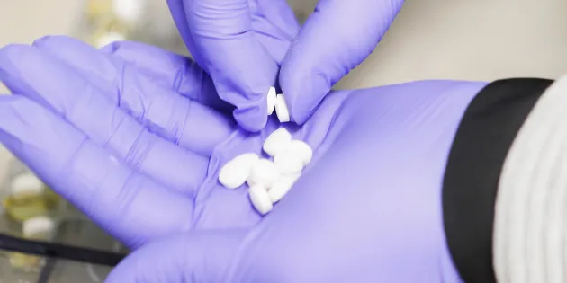 Tabletteja suojakäsineellisellä kämmenellä. 