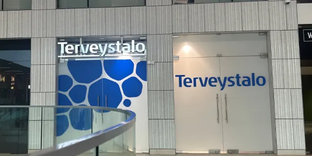 Terveystalon logo rakennuksen seinällä.