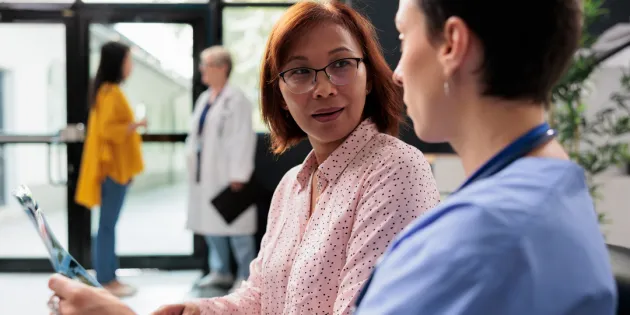 Hoitaja keskustelemassa potilaan kanssa.