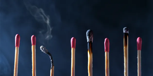 Tulitikkuja rivissä kuvaamassa työssä jaksamista ja uupumista. Välissä on palaneita tikkuja.