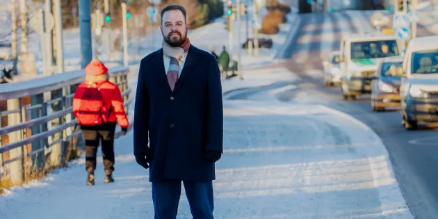 Ensihoitaja Aapo Liukko talvisessa kaupunkilimjöössä vilkkaan autotien vieressä.