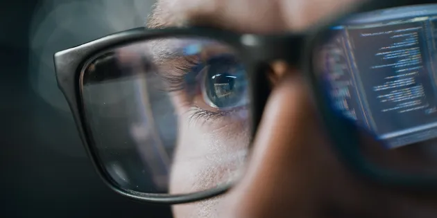 Silmälaseista heijastuu tietokoneen näyttö. 