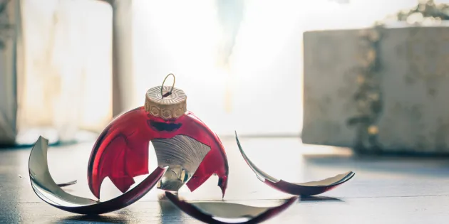 Rikkinäinen joulupallo lattialla.