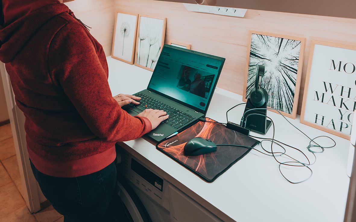 Tietokone kodinhoitohuoneessa pyykkikoneen päällä.