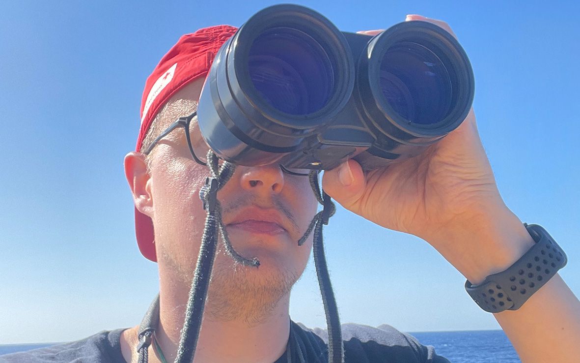 Henri Backman tähystää kiikareilla.