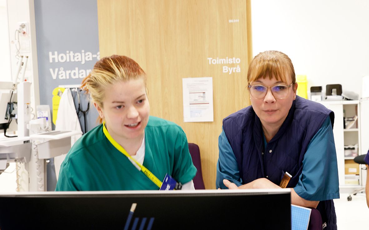 Kipuhoitajat Anetta Lemström ja Eveliina Ryynänen tietokoneen äärellä.