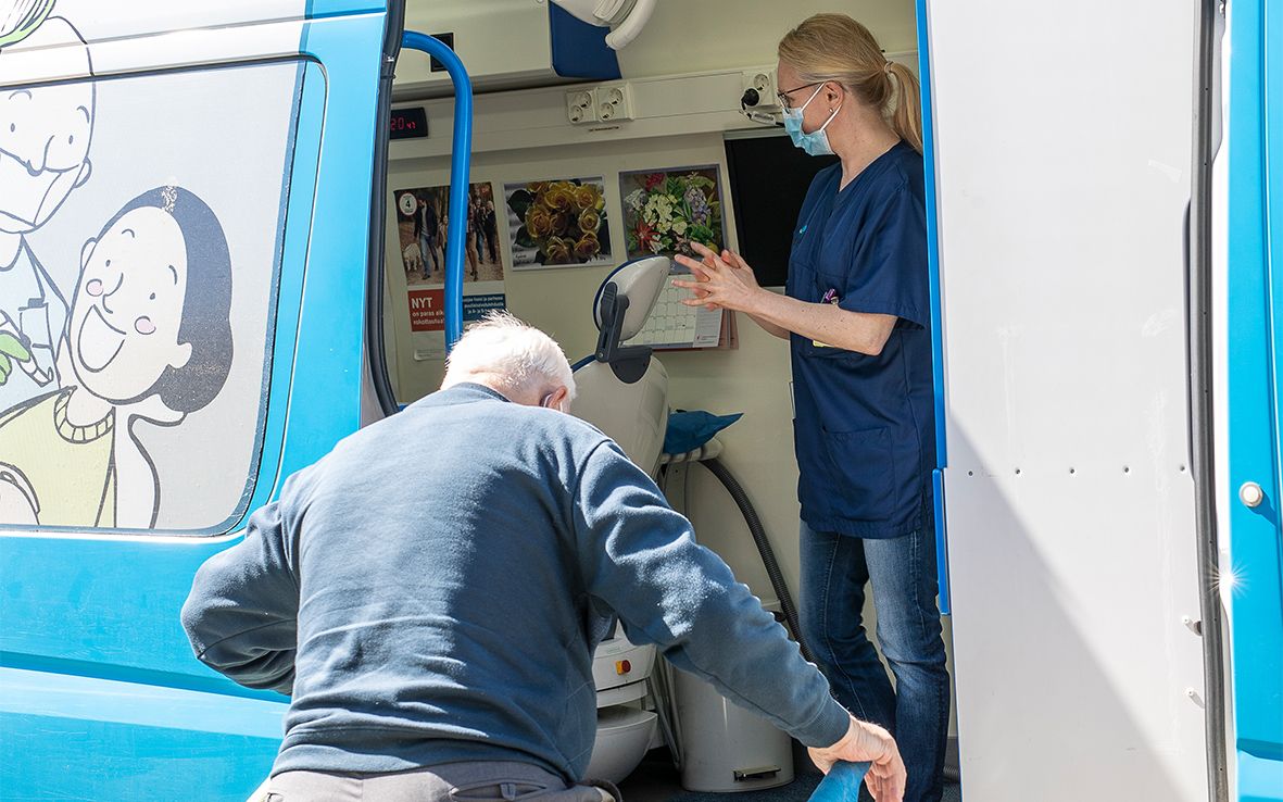 Potilas nousee autoon kaiteesta kiinni pitäen.