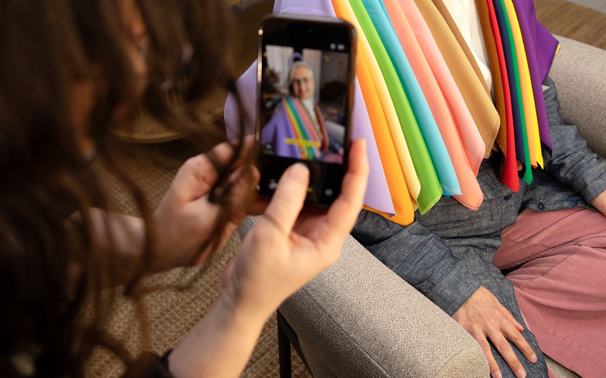 Toimittajan harteille on ripustettu erivärisiä kankaita.