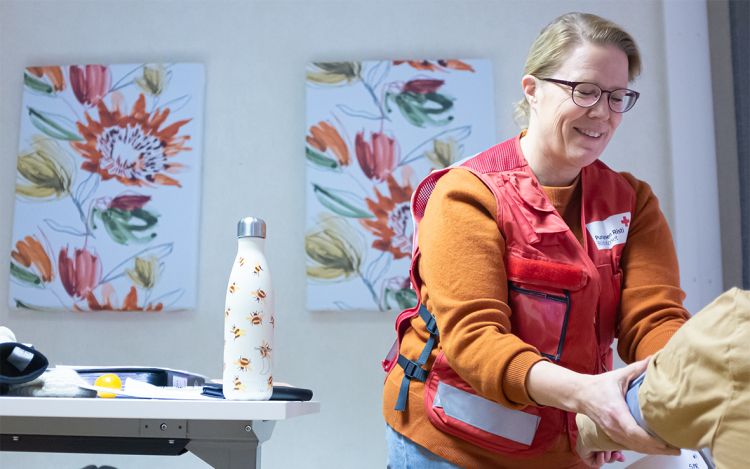 SPR:n liiveihin pukeutunut Päivi Laine asiakkaan kanssa.