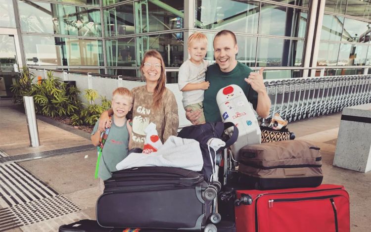 Riku Haataja perheineen lentokentällä matkalaukkujen kanssa.