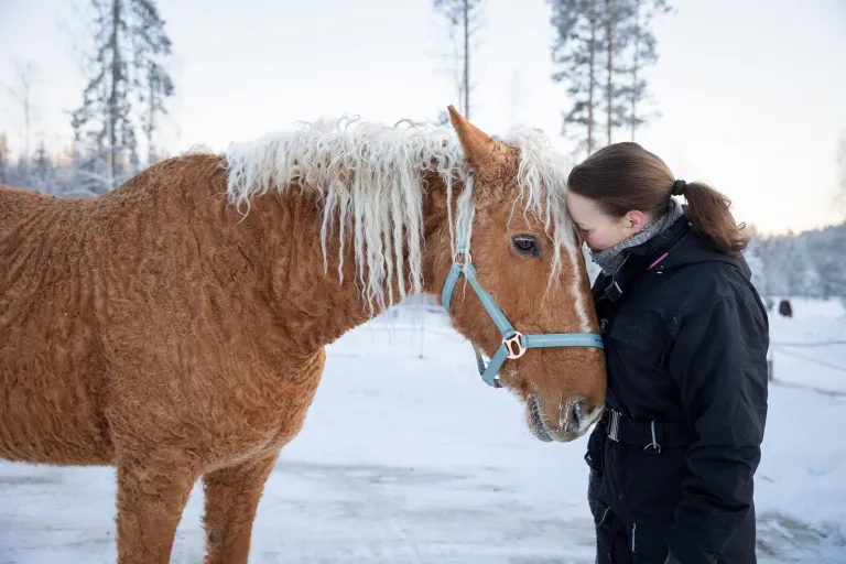 Terveydenhoitaja Nina Salonen ja Peppi-hevonen.