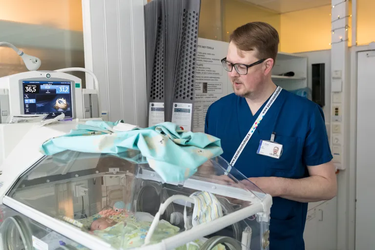 Kätilö Erik Indola Oysin sairaalassa vastasyntyneiden teho-osastolla keskoskaapin äärellä.