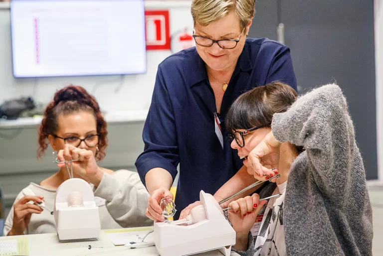 Hoitajat harjoittelevat gynekologisella harjoitussimulaattorilla.