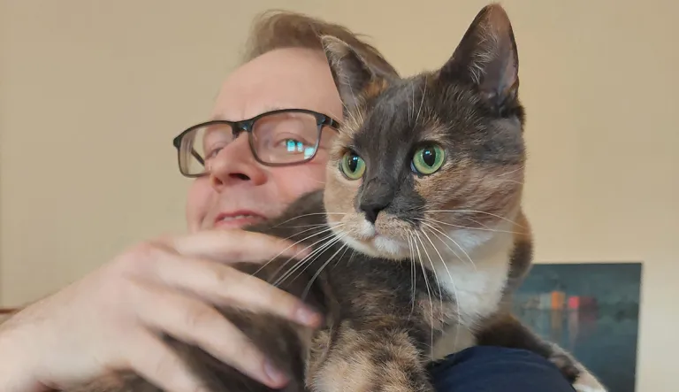 Vilma-kissa Jyri Meriläisen sylissä.