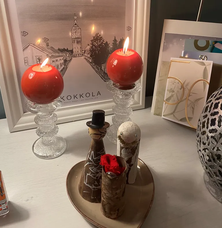 Jouluinen asetelma, kynttilöitä ja koristeita.