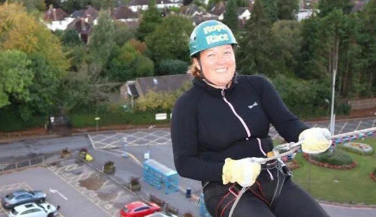 Taija Nenonen kiipeilyvaljaissa ja kypärä päässä.