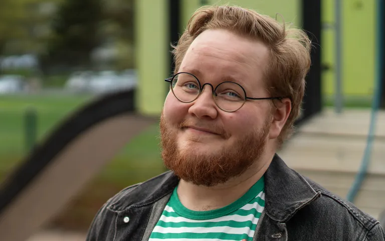 Nooa Sammalkäpy hymyilee kameralle. Kuva otettu lasten leikkikentällä.