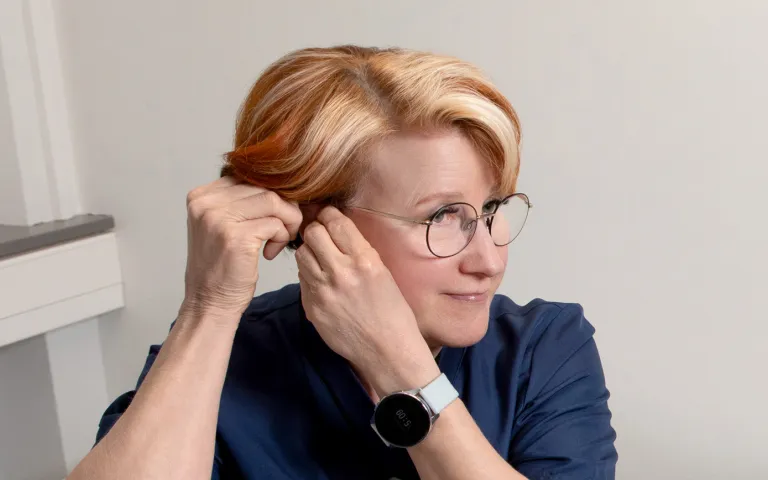 Sairaanhoitaja Leila Hällfors laittaa korvaansa kuulolaitetta.