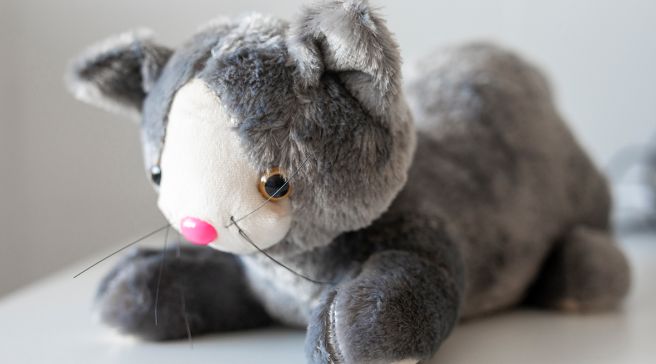 Harmaa painokissa, joka näyttää tavalliselta pehmolta, mutta on painava.