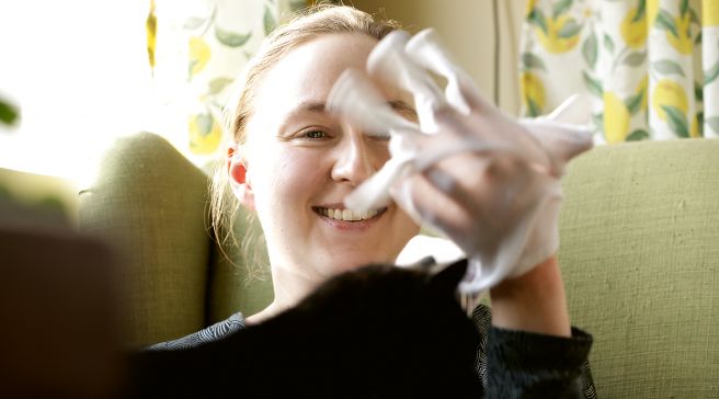 Katariina Peura laittaa puuvillahanskoja käteen.