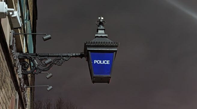 Lontoossa vanhanaikainen lamppu, jossa Police-teksti.