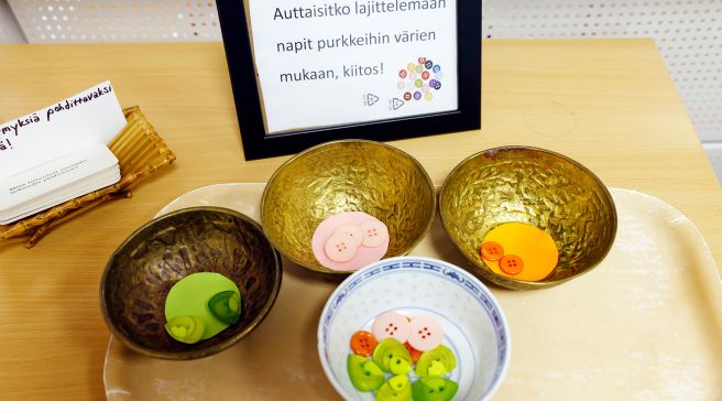 Erivärisiä nappeja erivärisissä kulhoissa.