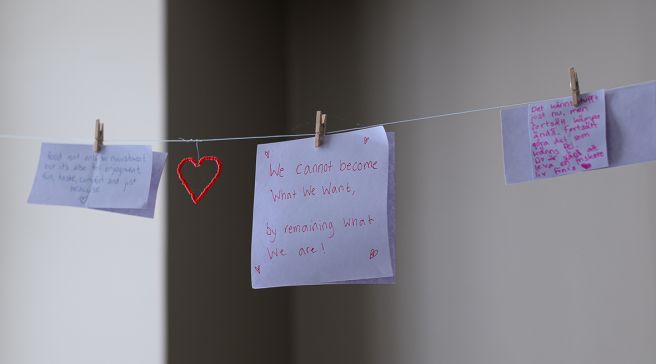 Potilaiden kirjoittamia muistilappuja roikkumassa narulla.