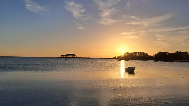 Maisemakuva merenrannalta, auringonlasku.