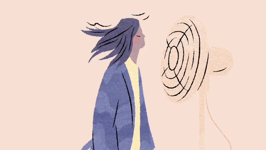 Nainen seisoo tuulettimen edessä. Hiukset hulmuavat.