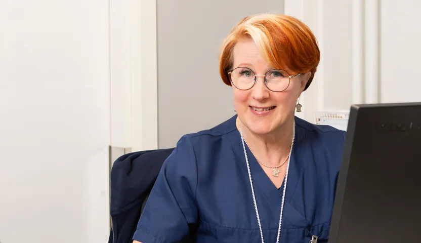 Sairaanhoitaja Leila Hällfors tietokoneen ääressä.