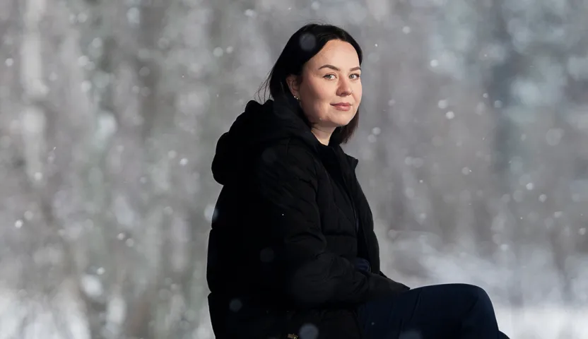 Sairaanhoitaja Elisa Lepistö istuu. Luminen talvimaisema taustalla.