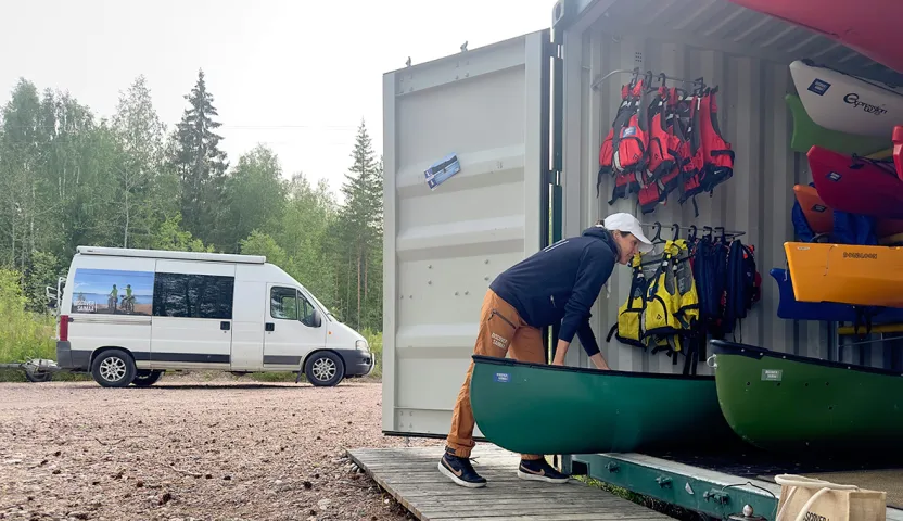 Taru Kaljunen nostaa kanoottia pois metallisesta varastokontista.