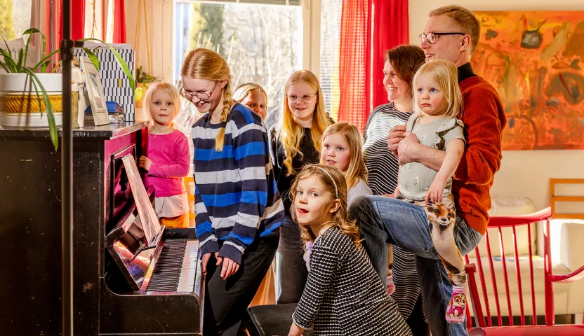 Mauno Kinnunen perheensä kanssa pianon äärellä.