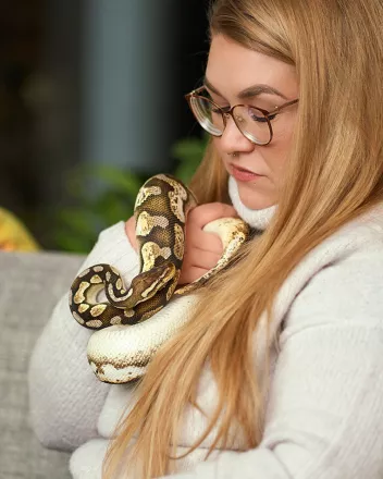 Lähihoitaja Noora Hjelman lemmikkikäärmeen kanssa.