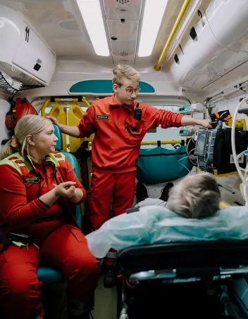 Pauliina Huovila ja Veeti Soini potilaan vieressä ambulanssissa.
