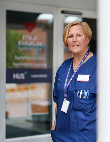 Sairaanhoitaja Liisa Hyttinen seisomassa Sammonlahden terveysaseman edustalla.