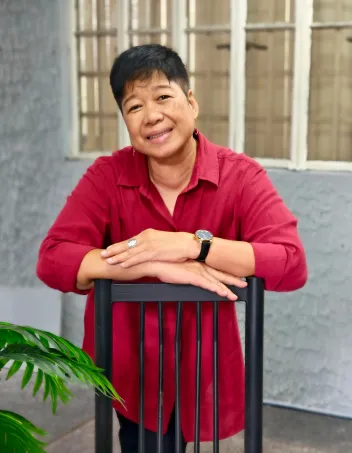 Annie Geron nojaamassa tuolin selkämykseen.